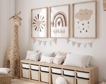 May include: A nursery room with a wooden storage bench with white bins, a stuffed giraffe, and three framed prints with a sun, a rainbow with the name "SARAH", and a cloud with raindrops.
