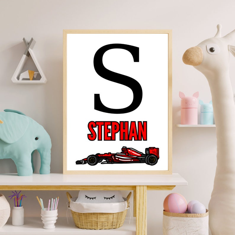Peut inclure: Une affiche imprimable blanche avec une lettre S noire et le nom Stephan en lettres rouges. Une voiture de course rouge est en bas de l'affiche.