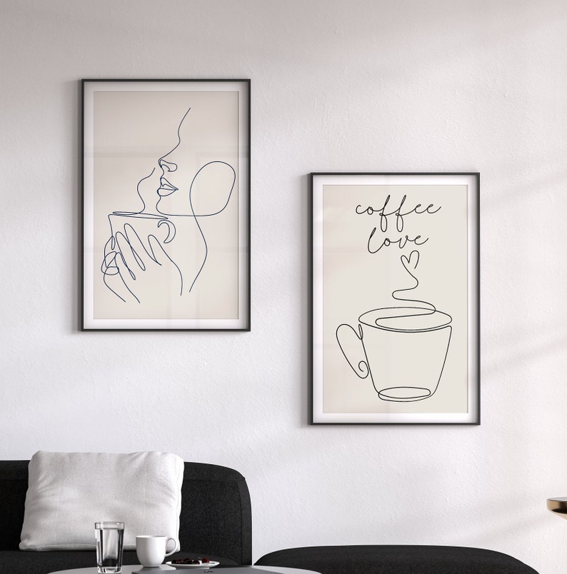 May include: Two framed illustrations with a minimalist line art style. The first illustration shows a person drinking from a cup with steam rising from the cup. The second illustration shows a cup of coffee with steam rising from the cup and the text "coffee love" written above the cup.
