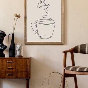 May include: A framed print with a black and white line drawing of a coffee cup with steam rising from it. The text "coffee love" is written above the cup with a small heart symbol.