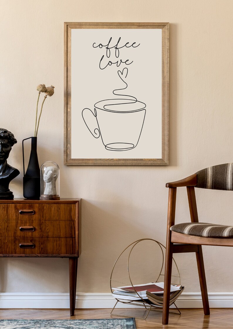 May include: A framed print with a black and white line drawing of a coffee cup with steam rising from it. The text "coffee love" is written above the cup with a small heart symbol.