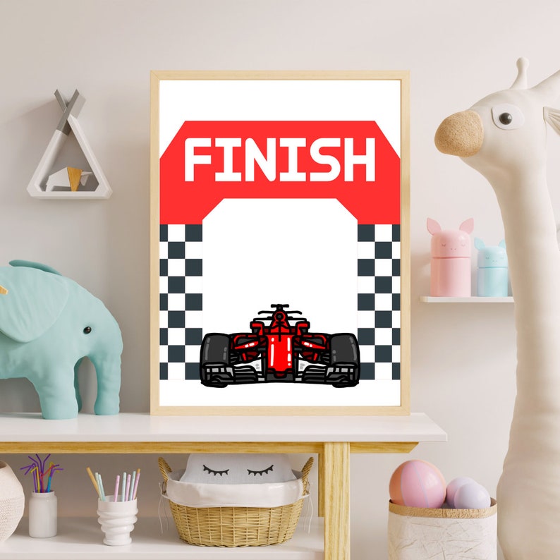 Peut inclure: Une affiche imprimable repr&eacute;sentant une voiture de course rouge franchissant une ligne d'arriv&eacute;e &agrave; damier avec le mot "FINISH" sur une banni&egrave;re rouge au-dessus.