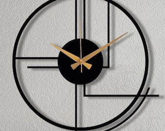 Könnte beinhalten: Eine runde Wanduhr mit einem schwarzen Metallrahmen, geometrischen Linien und einem zentralen schwarzen Zifferblatt. Die Uhr hat drei dünne, goldfarbene Zeiger, die einen Kontrast zum schwarzen Zentrum bilden und ein lineares Design erzeugen.