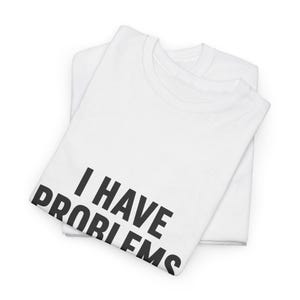 Peut inclure: Un t-shirt blanc à manches courtes avec le texte noir I HAVE PROBLEMS imprimé dans une police sans empattement en gras sur la partie inférieure avant. Le vêtement est plié proprement, révélant un col rond et une esthétique épurée.