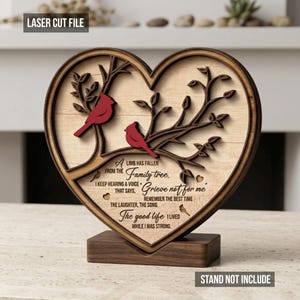 May include: A wooden heart-shaped laser-cut decoration featuring two red birds perched on a tree branch. The design includes the text "A limb has fallen from the family tree" and other related phrases. The base is a separate wooden stand.