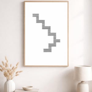Puede incluir: Lámina artística enmarcada con un diseño minimalista de una escalera en blanco y negro. La obra utiliza líneas horizontales para formar los escalones. El marco es de madera clara, ideal para interiores contemporáneos. Medidas: aprox. 50 cm x 70 cm.