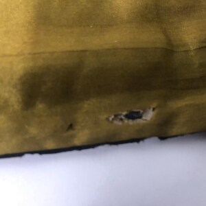 Puede incluir: Primer plano de una tela de color amarillo mostaza con un peque&ntilde;o agujero en el centro.
