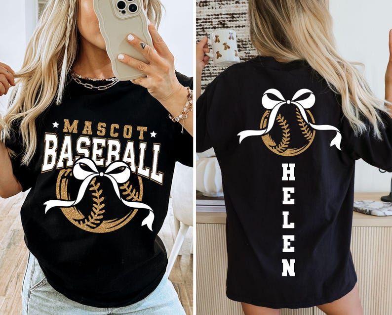 Peut inclure: T-shirt de baseball noir avec un motif dor&eacute; et blanc. Le devant affiche "MASCOT BASEBALL" au-dessus d'un graphisme de baseball avec un n&oelig;ud blanc. Le dos pr&eacute;sente un graphisme de baseball avec un n&oelig;ud et le nom "HELEN".