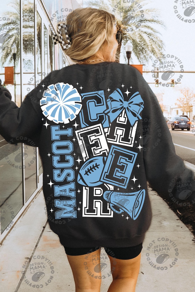 May include: A black long-sleeve sweatshirt featuring a large graphic on the back with the word CHEER in block letters, a football, a megaphone, a pom-pom, and a bow. The design is in light blue and white with small star accents throughout.