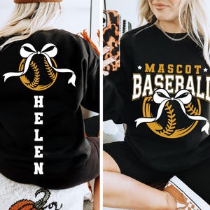Peut inclure: Sweat-shirt noir avec un motif de baseball et le texte "MASCOT BASEBALL". Le motif comprend une balle de baseball avec un n&oelig;ud et un ruban blancs. Le dos du sweat-shirt porte le nom "HELEN" en blanc.