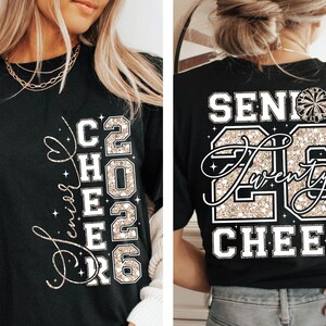 May include: Black t-shirt with gold glitter text. The front reads "Senior Cheer 2026" with a heart design. The back of the shirt says "Senior 26 Twenty Cheer" with a cheerleader graphic. A stylish shirt for cheerleaders.
