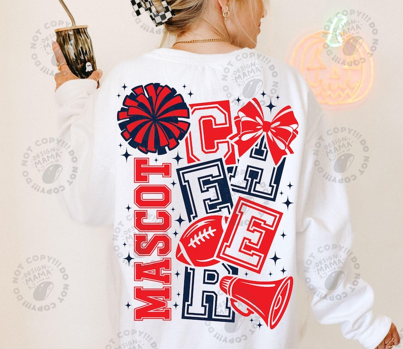 May include: A white long-sleeve sweatshirt featuring a large graphic on the back with the word CHEER in bold block letters, the word MASCOT, a red and blue pom-pom, a red hair bow, a red football, and a red megaphone, all accented with small stars.