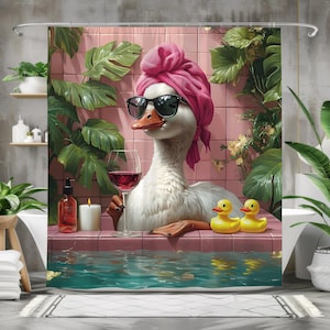 May include: A white duck with a pink towel on its head is relaxing in a bathtub. The duck is wearing sunglasses and holding a glass of red wine. Two yellow rubber duckies are floating in the water. The bathtub is surrounded by pink tiles and green plants.