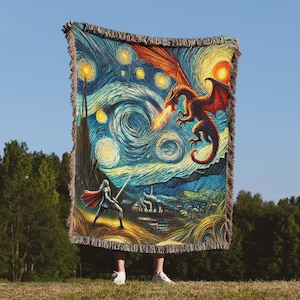 May include: A woven tapestry featuring a stylized depiction of a starry night sky with a dragon breathing fire and a knight standing on a hill. The tapestry is in a blue, yellow, and orange color scheme.