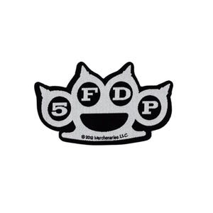May include: A black and silver embroidered patch shaped like brass knuckles. The design features the number 5 and the letters F, D, and P inside the circular openings. The text 2012 Merchenaries, L.L.C. is embroidered in small black letters at the bottom.