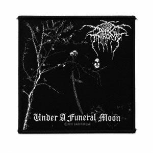 May include: A square black fabric patch featuring a white graphic print of a leafless tree and a face. The text Darkthrone is printed in a stylized font at the top right, with Under A Funeral Moon and 2010 DARKTHRONE printed at the bottom.