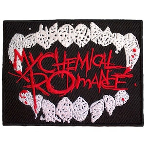 Peut inclure: Un écusson rectangulaire brodé noir représentant des crocs de vampire blancs en haut et en bas. Le texte My Chemical Romance est brodé en rouge au centre, avec de petites touches rouges rappelant des gouttes de sang sur les crocs blancs.