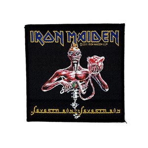 Op de afbeelding: Een vierkante zwarte geborduurde patch met het Iron Maiden-logo in blauwe en gele tekst. De afbeelding toont een skeletfiguur die een rood hart vasthoudt, met de tekst Seventh Son of a Seventh Son in het geel onderaan en copyright-vermelding.