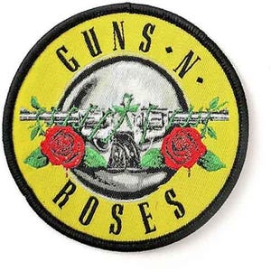 Könnte beinhalten: Runder, gestickter Aufnäher mit gelbem Hintergrund und schwarzem Rand. Das Design zeigt den Text "GUNS N' ROSES" in Schwarz, der ein silbernes Bild einer Waffe mit roten Rosen und grünen Blättern umgibt.