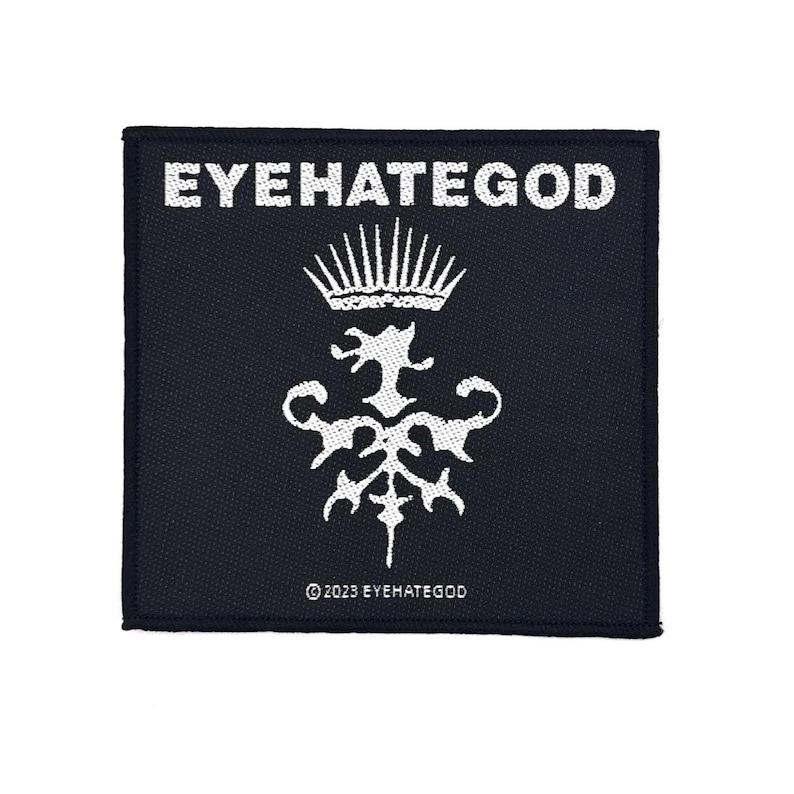 May include: A square, black patch featuring white text and a white graphic. The text "EYEHATEGOD" is at the top, with a crown and ornate design below. The text "&copy; 2023 EYEHATEGOD" is at the bottom of the patch.