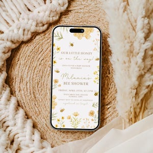 Op de afbeelding: Een digitale uitnodiging voor een babyshower met een bijen thema. De uitnodiging heeft een geel honingraatpatroon, bijen en bloemen. De tekst luidt "Onze kleine honing is onderweg!" en "Melania's Bijenbabyshower". De datum en tijd van de babyshower zijn aangegeven als "Vrijdag 15 april, om 14:00 uur".