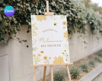 Op de afbeelding: Een welkomstbord voor een babyborrel met een bijen thema. Het bord is wit met gele en groene aquarelbloemen en honingraten. De tekst luidt "Welkom bij Melania's Bee Shower".