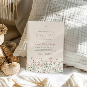 Puede incluir: Una tarjeta blanca con detalles florales rosas y el texto "&Uacute;nase a nosotros para celebrar el bautismo de nuestra hija Amelia Smith. S&aacute;bado, 7 de octubre a las 4 PM. Iglesia parroquial de San Pablo, 2774 Flowers Street, Los &Aacute;ngeles. RSVP antes del 1 de octubre al 123-456-7890."