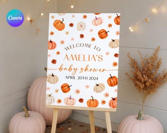 May include: A baby shower welcome sign on an easel. The sign features watercolor pumpkins and flowers in shades of orange, white, and peach. Text reads "Welcome to Amelia's baby shower April 20th 2024."