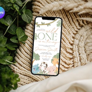 May include: A smartphone displays a baby shower invitation with the text "Our Little Wild One is on the Way." The invitation features illustrations of a rhino, zebra, elephant, and giraffe. The background includes green leaves and a beige woven texture.
