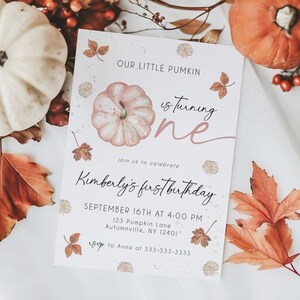 May include: A fall-themed invitation with the text "Our Little Pumkin is turning one." The invitation features a watercolor pumpkin illustration, autumn leaves, and the text "Kimberly's first birthday."