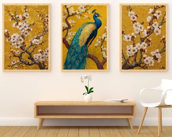 May include: Three framed art prints with a peacock and flowering branches on a gold background. The peacock has blue and gold feathers. The branches have white blossoms. The frames are light brown.