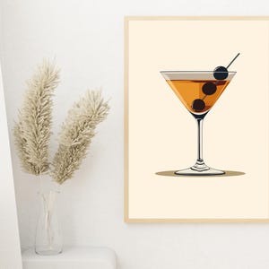 May include: A printable art print featuring a minimalist illustration of a martini glass with olives. The glass is filled with a light orange liquid and the background is a light beige color.