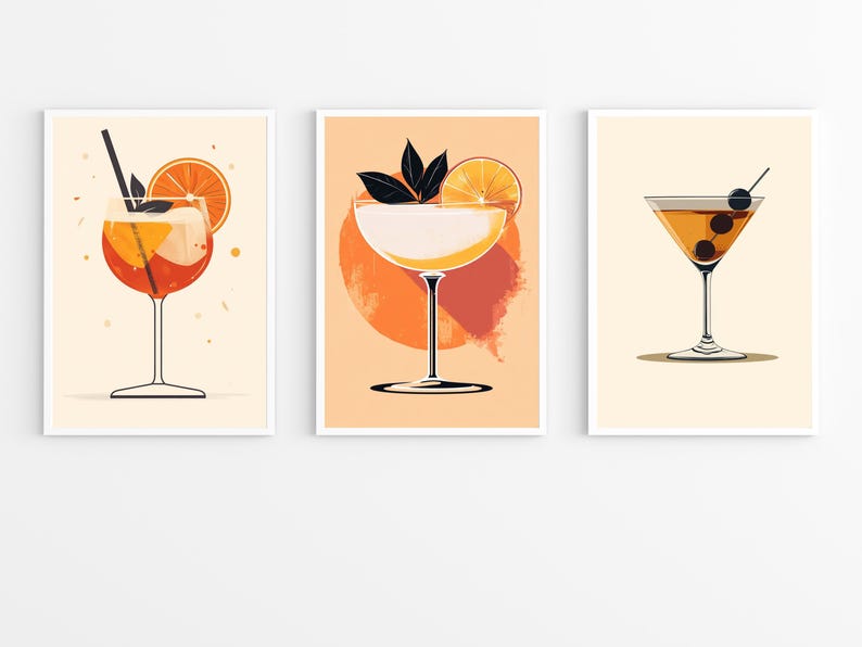 May include: Three printable art prints featuring illustrations of cocktails. The first print shows an orange and red cocktail with a slice of orange. The second print shows a white cocktail with a slice of orange and green leaves. The third print shows a brown cocktail with two olives.