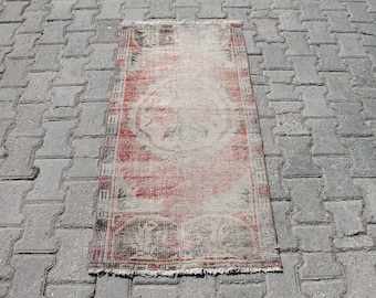 May include: A vintage red and white rug with a floral pattern. The rug has a fringe border and is in good condition.