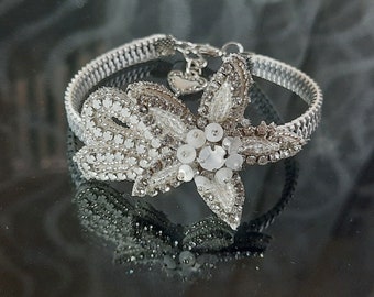 Delicate, White metal zipper bracelet with a silver-tone beaded flower. Bridal jewelry.