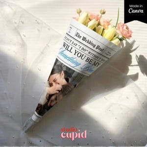 以下が含まれることがあります： 黄色いチューリップとピンクの花の花束。新聞風の円錐に包まれています。「The Wedding Post」と「Will You Be My Something Blue」と書かれた新聞。画像には「studio cupid」と「Made in Canva」の文字も含まれています。