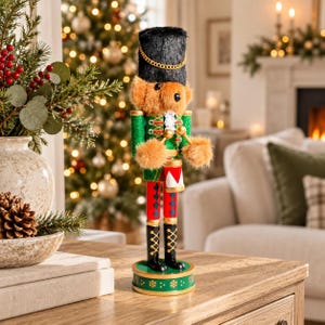 Può includere: Una statuetta schiaccianoci a forma di orsacchiotto che indossa un alto cappello nero peloso con una catena dorata, una giacca verde con finiture dorate e pantaloni rossi con motivi a rombi blu su una base circolare verde.