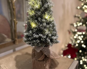 Árbol de Navidad grande, luminoso y escarchado con base de arpillera.