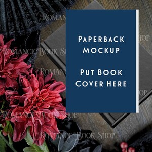 May include: A paperback book mockup with a dark blue cover, featuring the text "PAPERBACK MOCKUP" and "PUT BOOK COVER HERE". The image includes dark red flowers, black lace, and the text "ROMANCE BOOK SHOP".