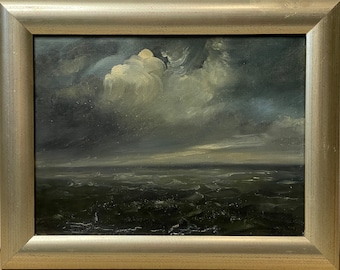 Op de afbeelding: Een ingelijst olieverfschilderij dat een zeezicht voorstelt met een enkele grote witte wolk in een donkerblauwe lucht boven golvend groen water.