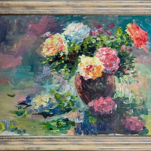 May include: An oil painting in a light brown wooden frame depicting a bouquet of colorful flowers in a dark brown vase. The artwork features thick, visible brushstrokes in shades of yellow, pink, red, and green against a muted background.