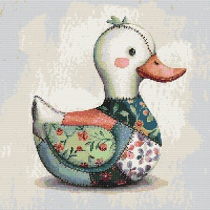 May include: A handmade patchwork duck with a white head, pink cheeks, and an orange beak. The duck's body is made of various fabric patches in green, blue, pink, and white, decorated with floral patterns. The background is a soft, textured, light blue.