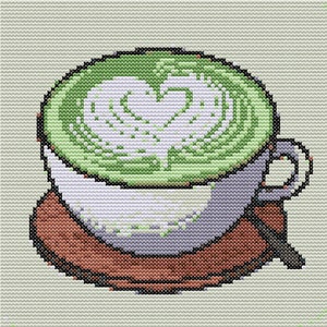 May include: Cross-stitch design of a cup of matcha latte with a heart-shaped foam design. The cup is white with a gray handle and sits on a brown saucer. The matcha is a vibrant green color.