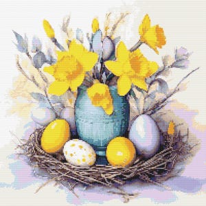 Op de afbeelding: Een blauwe vaas gevuld met gele narcissen staat op een tafel met een nest van takken en vier gevlekte eieren. Twee van de eieren zijn geel, één is wit met bruine vlekken en één is lichtblauw.