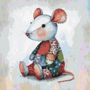 Op de afbeelding: Een witte patchworkmuis met rode, blauwe en groene stoffen accenten. De muis zit op een lichtblauwe achtergrond.