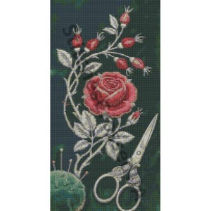 Puede incluir: Un patrón de punto de cruz con una rosa roja central rodeada de hojas blancas y escaramujos rojos. Debajo del arreglo floral, unas tijeras de bordar plateadas descansan junto a un alfiletero verde redondo con varias agujas.