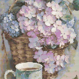 Op de afbeelding: Een wit theekopje met een bloemenpatroon staat op een tafel naast een mand vol met paarse en witte bloemen.