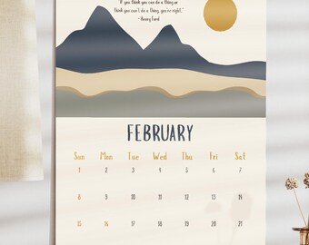 May include: A wall calendar for February with a landscape design featuring mountains and a sun. The calendar has a quote and a monthly view with dates. The calendar is hanging on a wall.