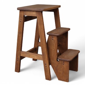 May include: A wooden step stool with two steps. The stool is made of dark brown wood and has a simple design.
