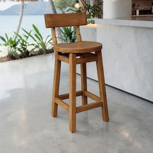 Op de afbeelding: Een houten barkruk met een medium bruine afwerking, voorzien van een ronde zitting, een rechthoekige rugleuning en vier rechte poten die aan alle zijden zijn verbonden door horizontale steunbalken. De kruk heeft een glad, gepolijst oppervlak.